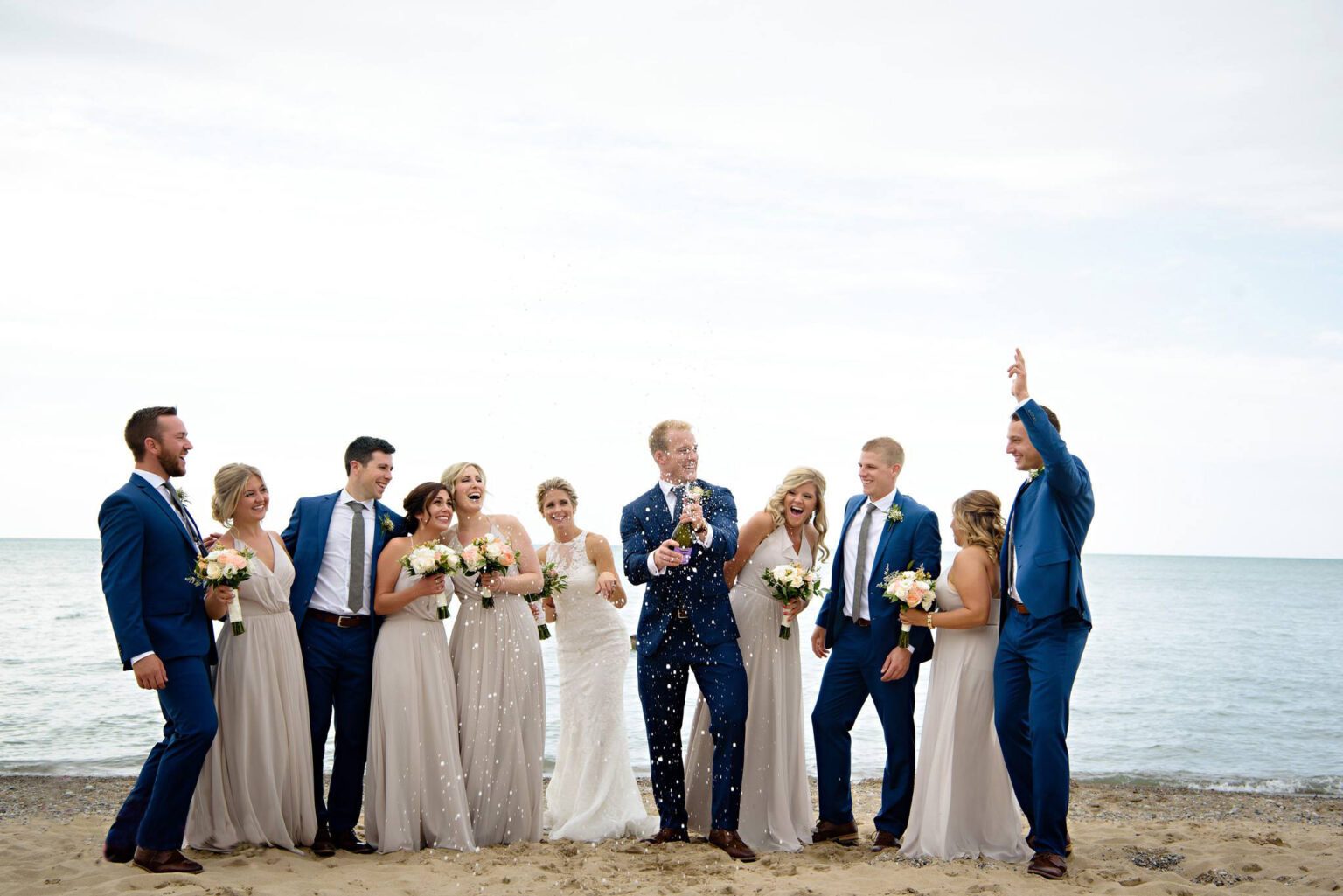 A wedding party celebrating on the beach